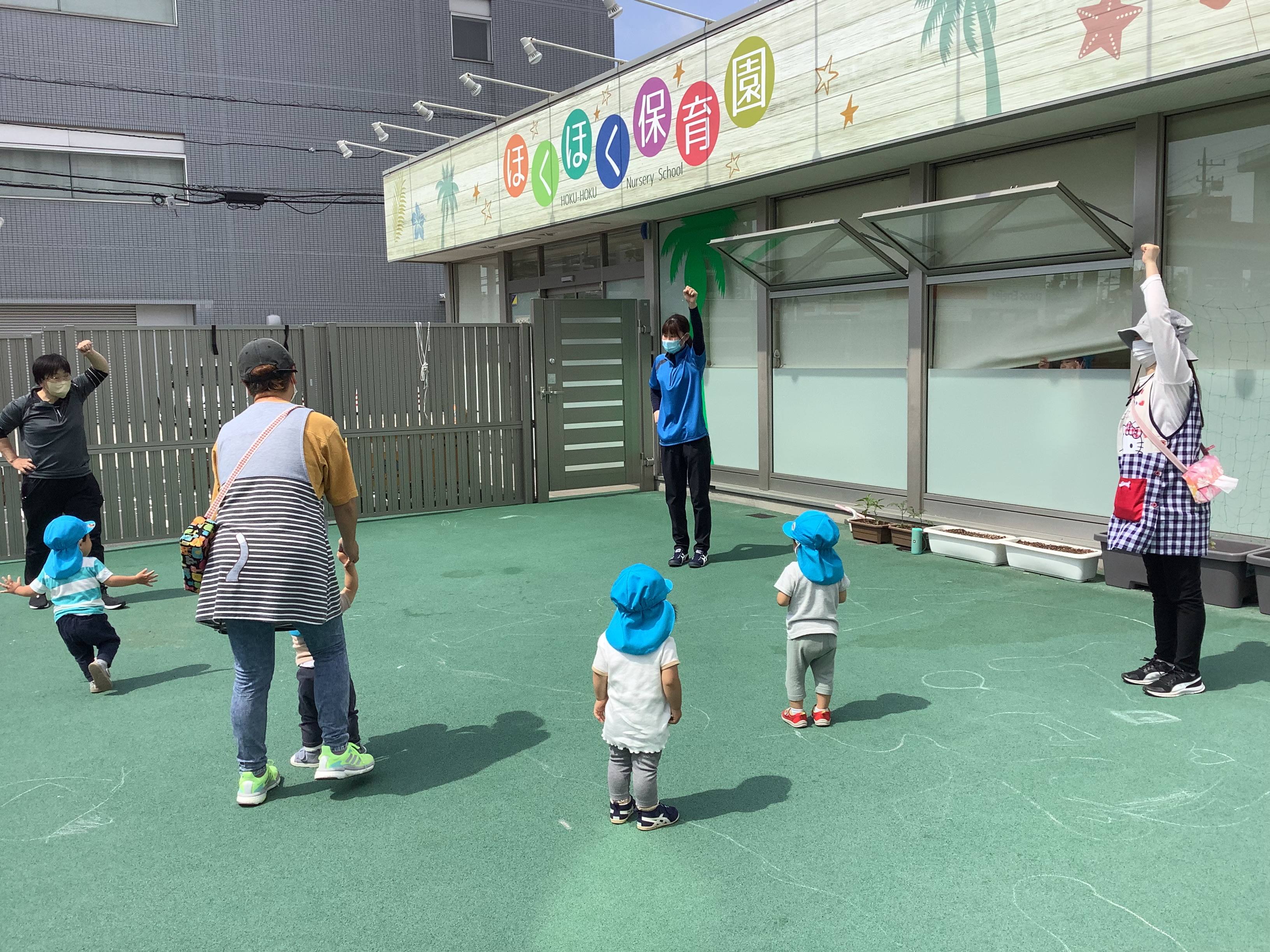 保育園で先生と一緒に過ごす子どもたち
